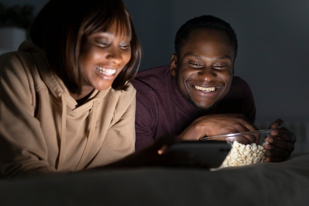 Foto grátis casal afro-americano assistindo a um serviço de streaming juntos