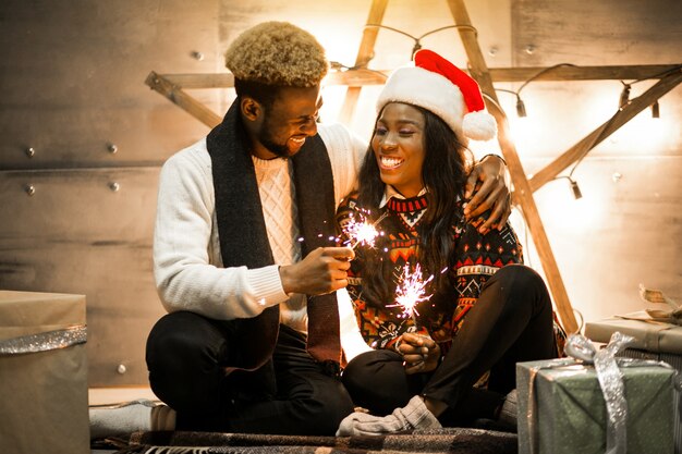 Casal afro-americano sentado com luzes de bengala