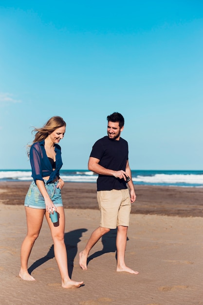 Casal alegre andando perto do mar