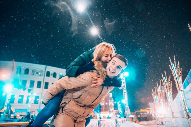 Casal alegre e brincalhão em roupas de inverno quente estão brincando