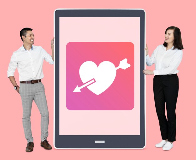 Casal alegre mostrando namoro on-line em um tablet
