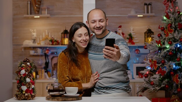 Casal alegre usando comunicação por videochamada no smartphone