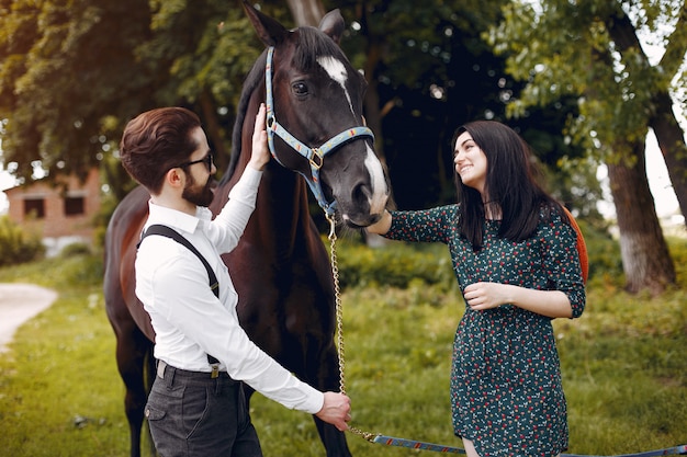 Casal amoroso bonito com cavalo na fazenda