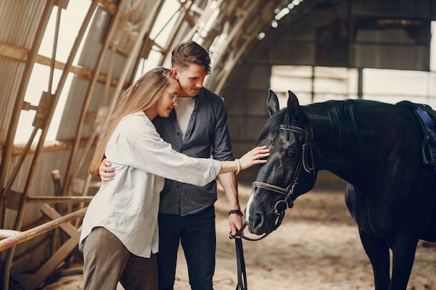 Casal amoroso bonito com cavalo na fazenda