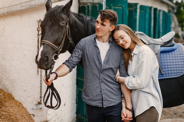 Casal amoroso bonito com cavalo na fazenda