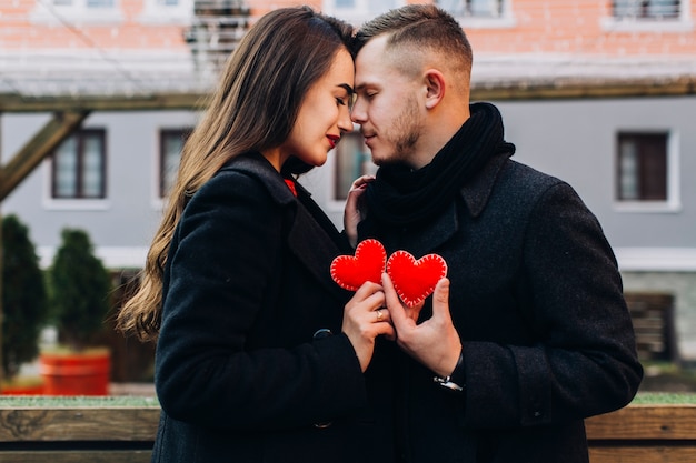 Foto grátis casal amoroso posando com corações vermelhos