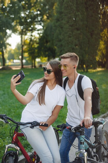 Casal andando de bicicleta na floresta de verão