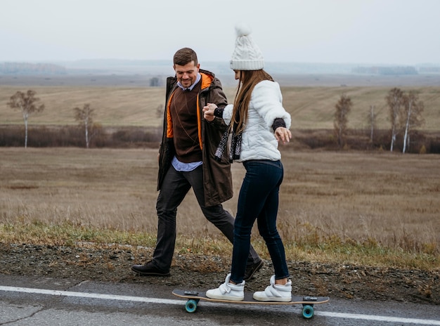 Casal andando de skate ao ar livre na estrada