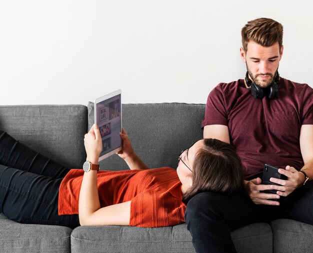 Casal anti-social relaxando no sofá