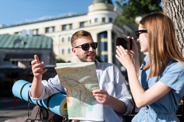 Casal ao ar livre com mochila e mapa