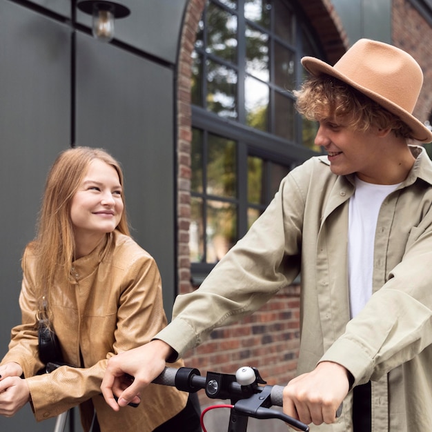 Casal ao ar livre na cidade com scooters elétricas