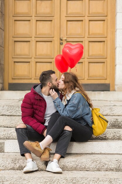 Casal apaixonado beijando ao ar livre tiro completo