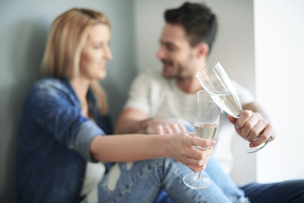 Casal apaixonado brindando com champanhe à nova casa