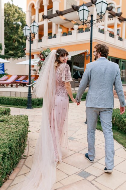 Casal apaixonado, caminhando em uma villa de luxo, enquanto celebra o casamento. Toda a extensão.