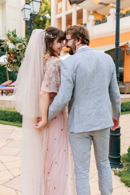 Casal apaixonado, caminhando em uma villa de luxo, enquanto celebra o casamento.