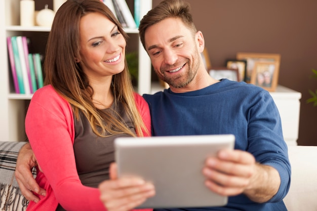 Casal apaixonado usando tablet digital em casa