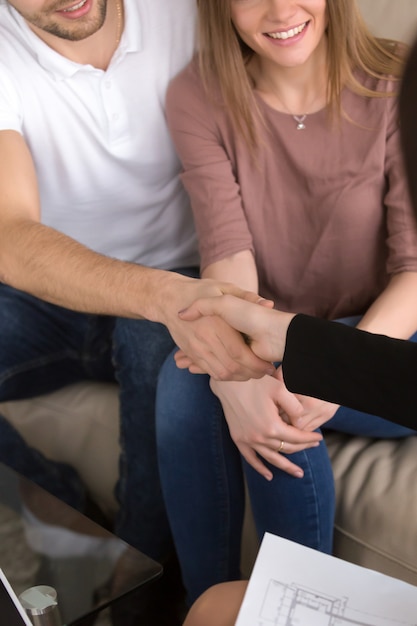 Foto grátis casal apertando as mãos com corretor de imóveis. renovação de imóveis e residências