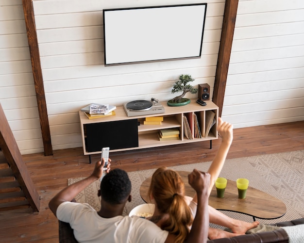 Casal assistindo serviço de streaming juntos na sala de estar