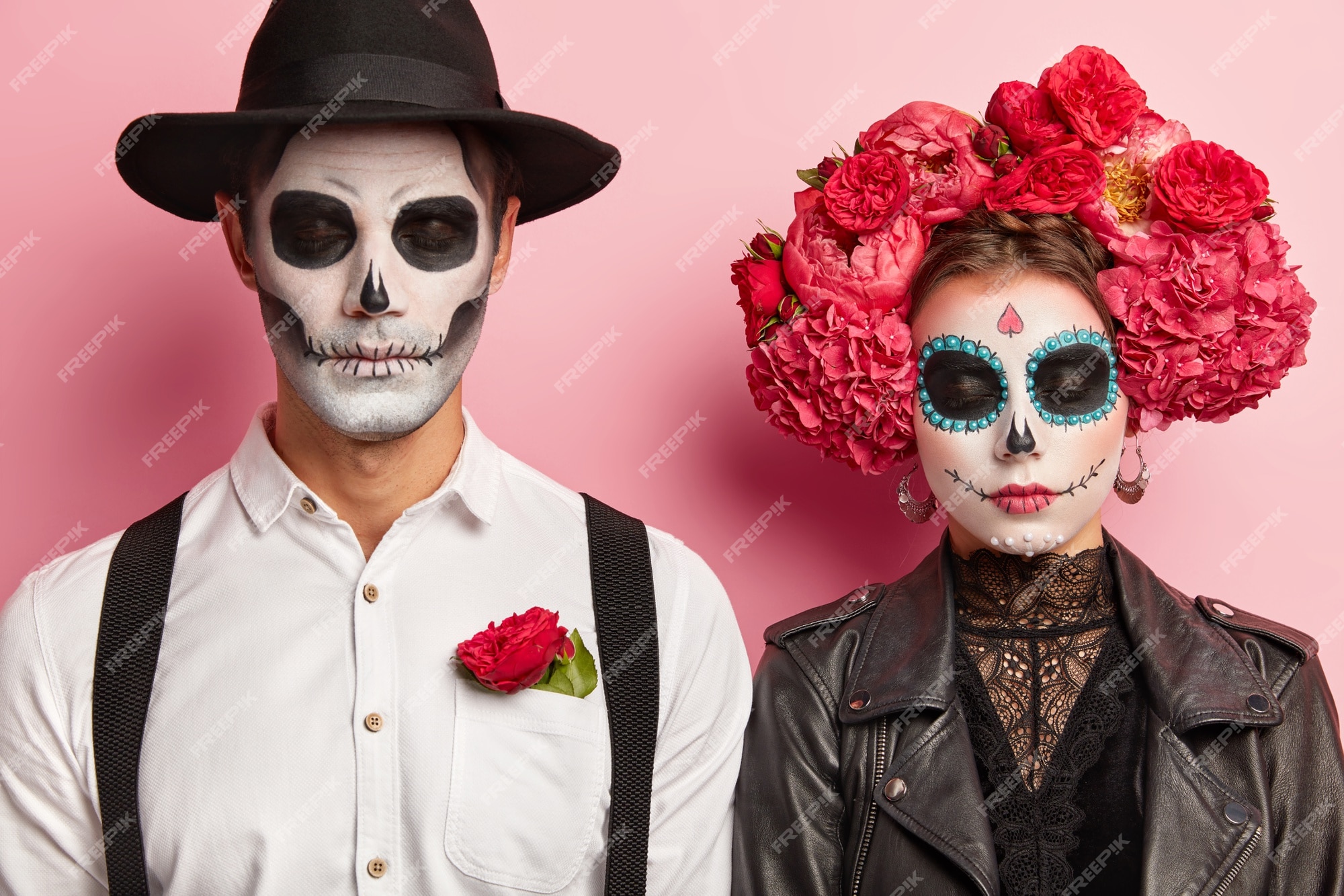 Casal assustador morto celebra o halloween juntos, organiza festa à fantasia,  usa trajes mexicanos tradicionais, maquiagem vívida, coroa de flores  vermelha, pose no estúdio, fica ombro a ombro. dia da morte