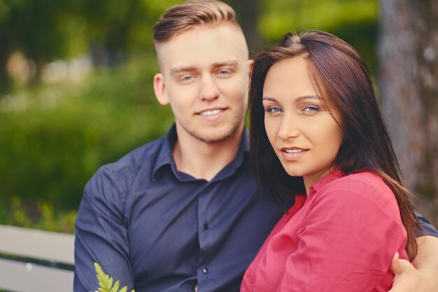 Casal atraente positivo em um encontro em um parque da cidade.