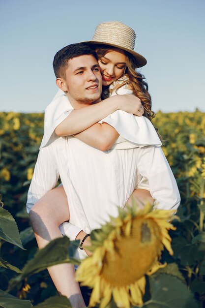 Casal bonito e elegante em um campo com girassóis