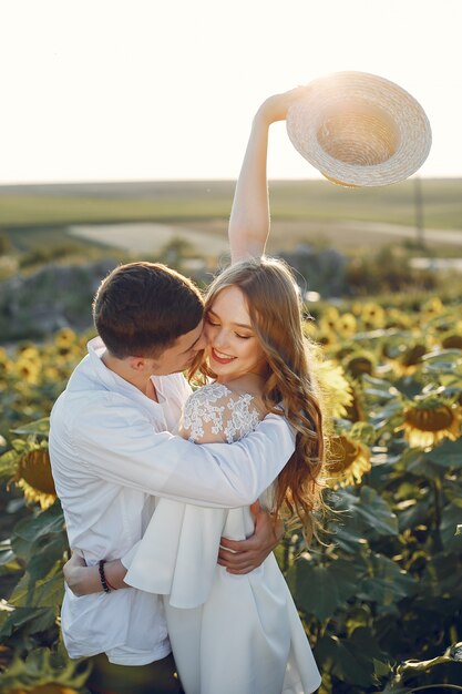 Casal bonito e elegante em um campo com girassóis