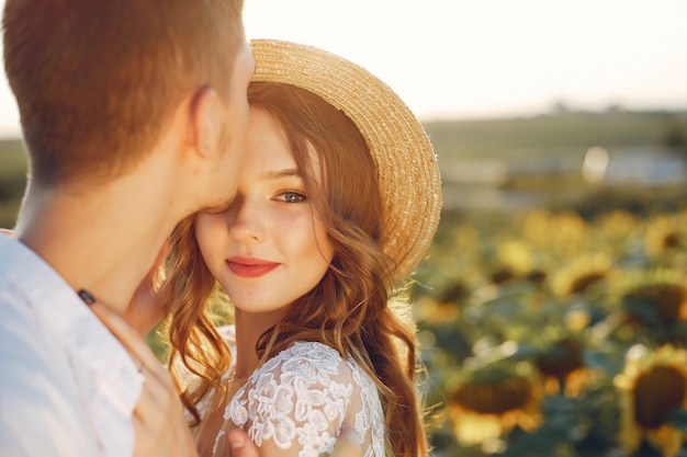 Casal bonito e elegante em um campo com girassóis