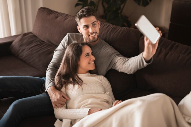 Casal bonito em casa no modelo de sofá