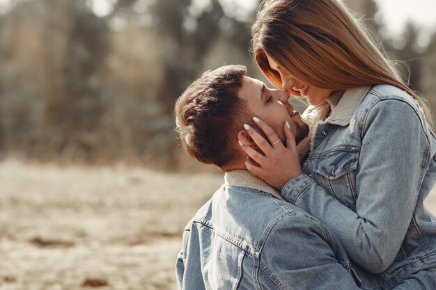 Casal bonito em uma roupa jeans em um campo de primavera