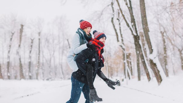 Casal brilhante alegre na floresta do inverno