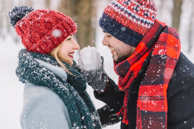 Casal brincalhão satisfeito com bolas de neve