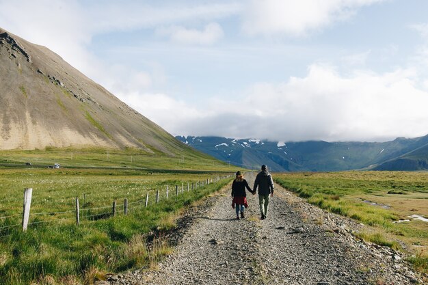 Casal caminhando em estrada de cascalho rural