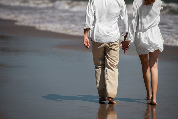 Casal caminhando na praia durante as férias