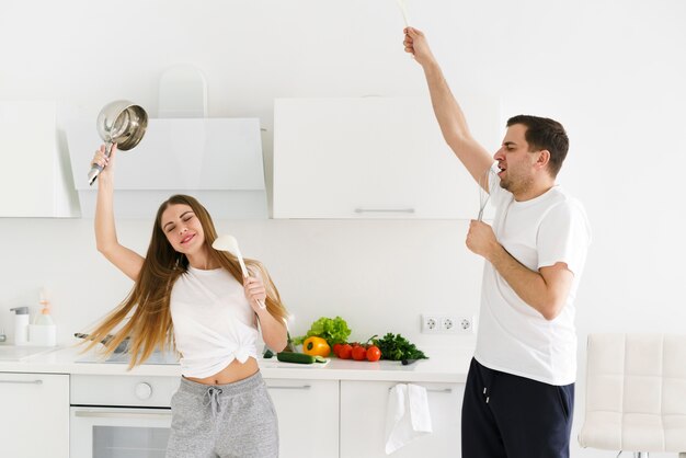 Casal cantando enquanto cozinha