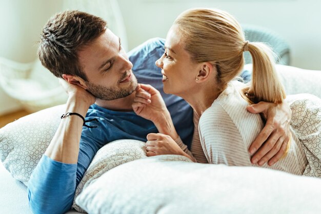 Casal carinhoso relaxando no quarto e conversando um com o outro