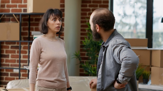 Casal carregando caixas de papelão no apartamento, comprando a primeira propriedade doméstica em empréstimo hipotecário. desempacotando as coisas para se mudar para uma nova casa juntos, investimento de realocação. tiro de mão.