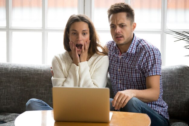 Casal chocado confuso e assustado assistindo filme de terror no laptop