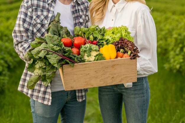 Casal close-up com cesta de legumes