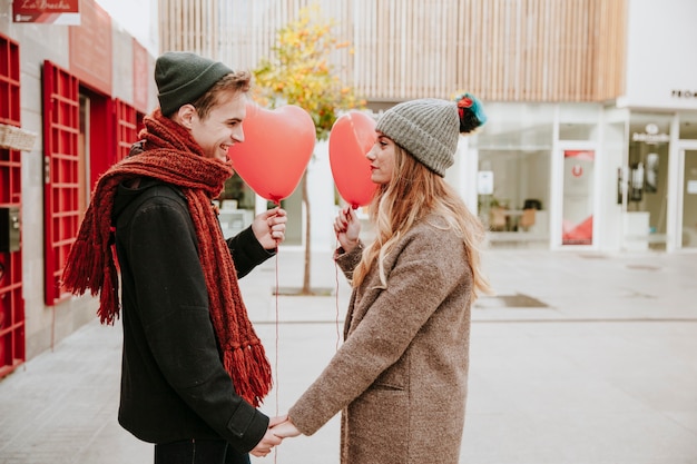 Casal com balões na rua