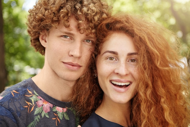 casal com cabelo ruivo cacheado relaxando ao ar livre