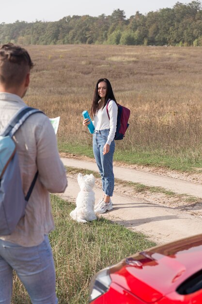 Foto grátis casal com cachorro e carro ao ar livre