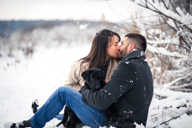 Casal com cachorro no inverno