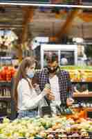 Foto grátis casal com máscara protetora médica em um supermercado.