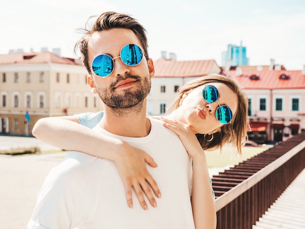 Casal com óculos de sol posando na rua