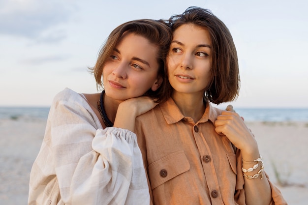 Casal com penteado curto em roupas de linho verão posando na praia