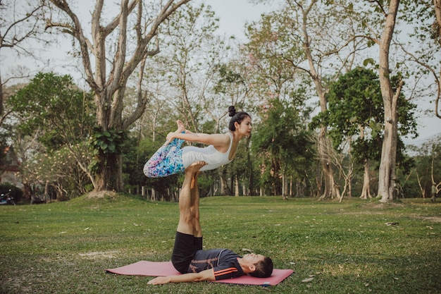 Casal com pose de yoga legal e acrobática