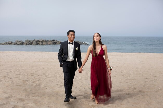 Casal com roupas de baile de formatura na praia