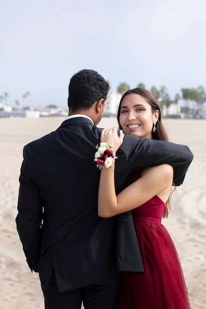 Casal com roupas de baile de formatura na praia