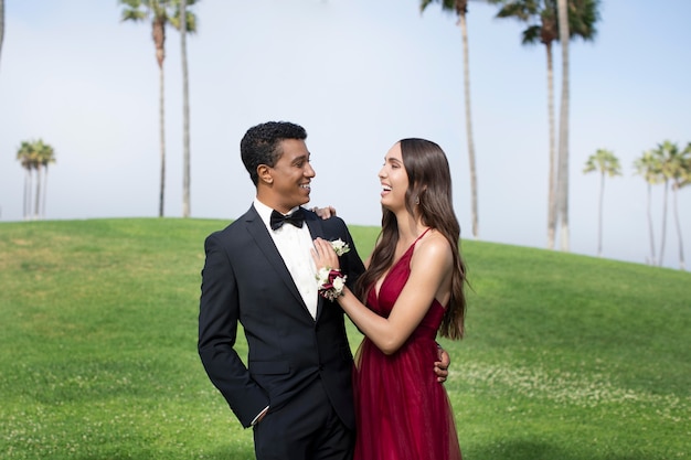 Casal com roupas de baile de formatura posando junto