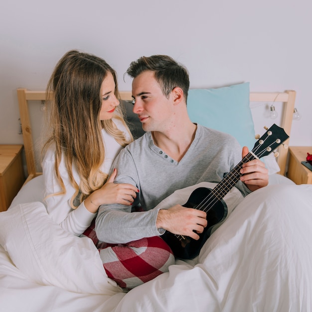 Casal com ukulele olhando um para o outro